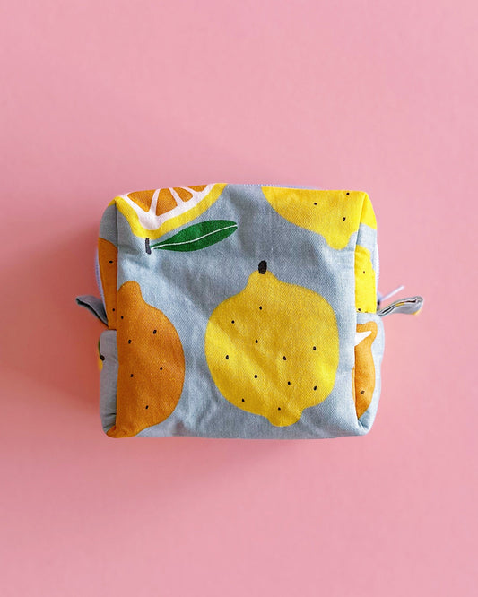 Small quilted zipper pouch with lemon and orange print on a pink background, handmade mini fabric bag, 10x10x5cm.