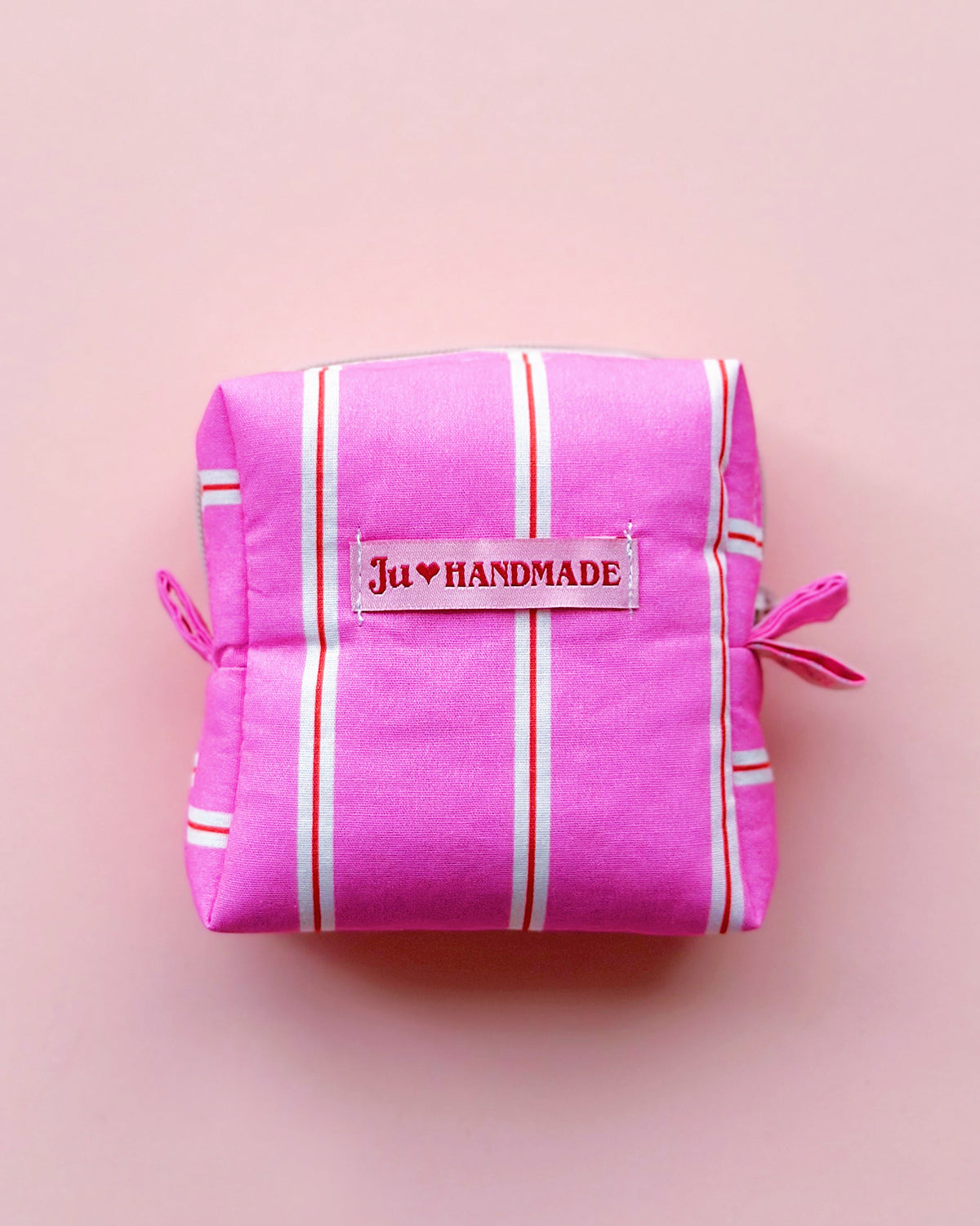 a boxy shape zipper pouch in pink striped fabric