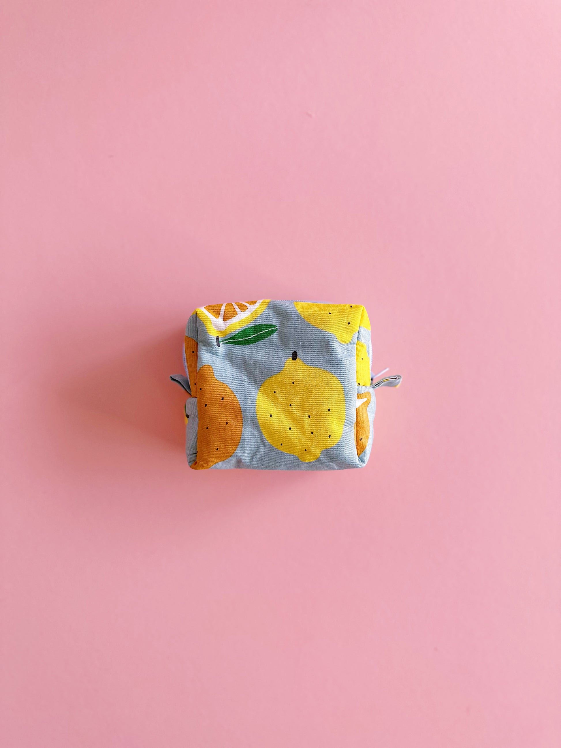 Small quilted zipper pouch with lemon and orange print on a pink background, handmade mini fabric bag, 10x10x5cm.