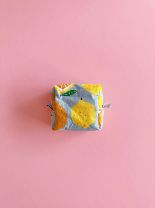 Small quilted zipper pouch with lemon and orange print on a pink background, handmade mini fabric bag, 10x10x5cm.