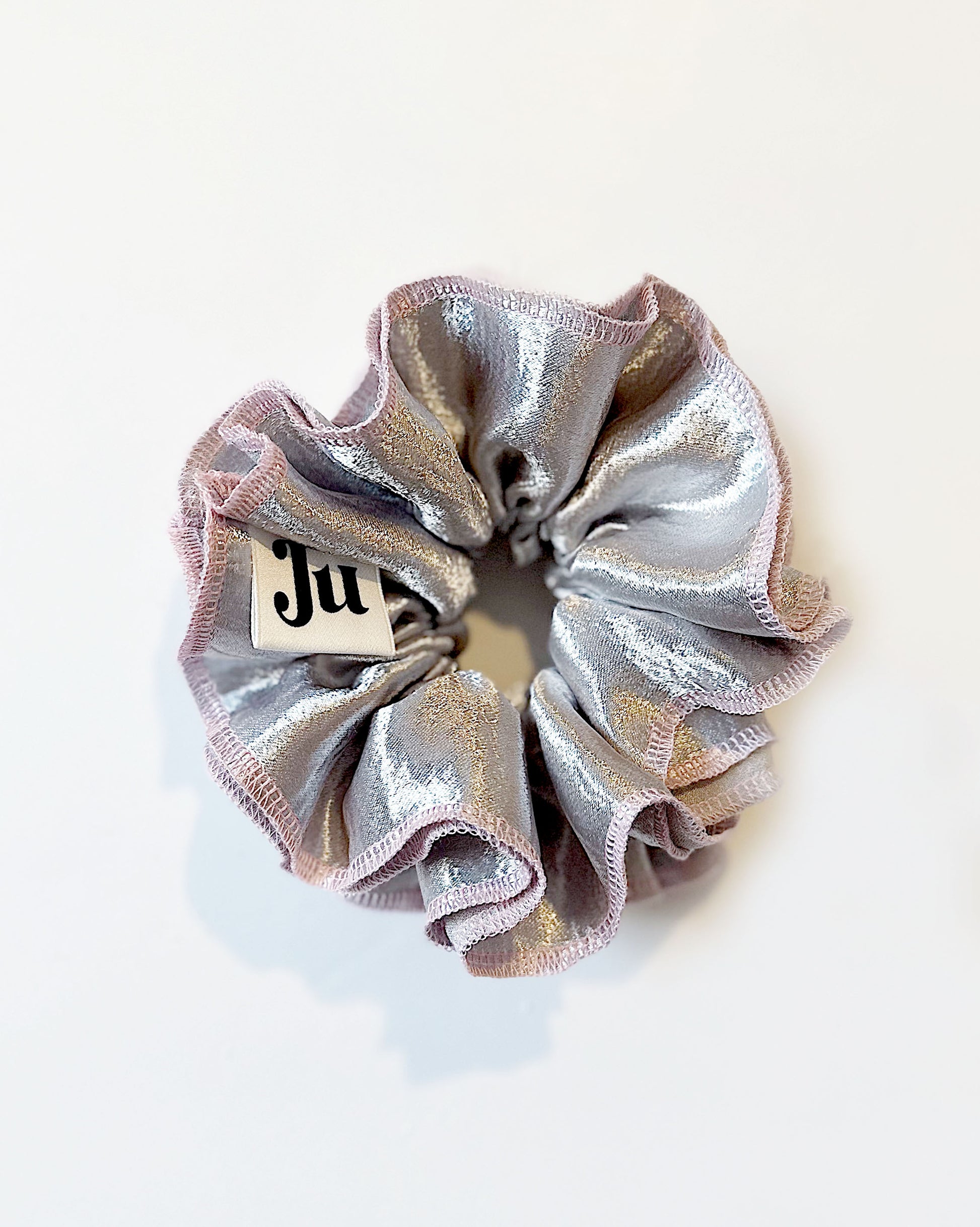 Oversized silver satin scrunchie with soft pink edges, shiny metallic hair accessory for Christmas party or festive hairstyles.