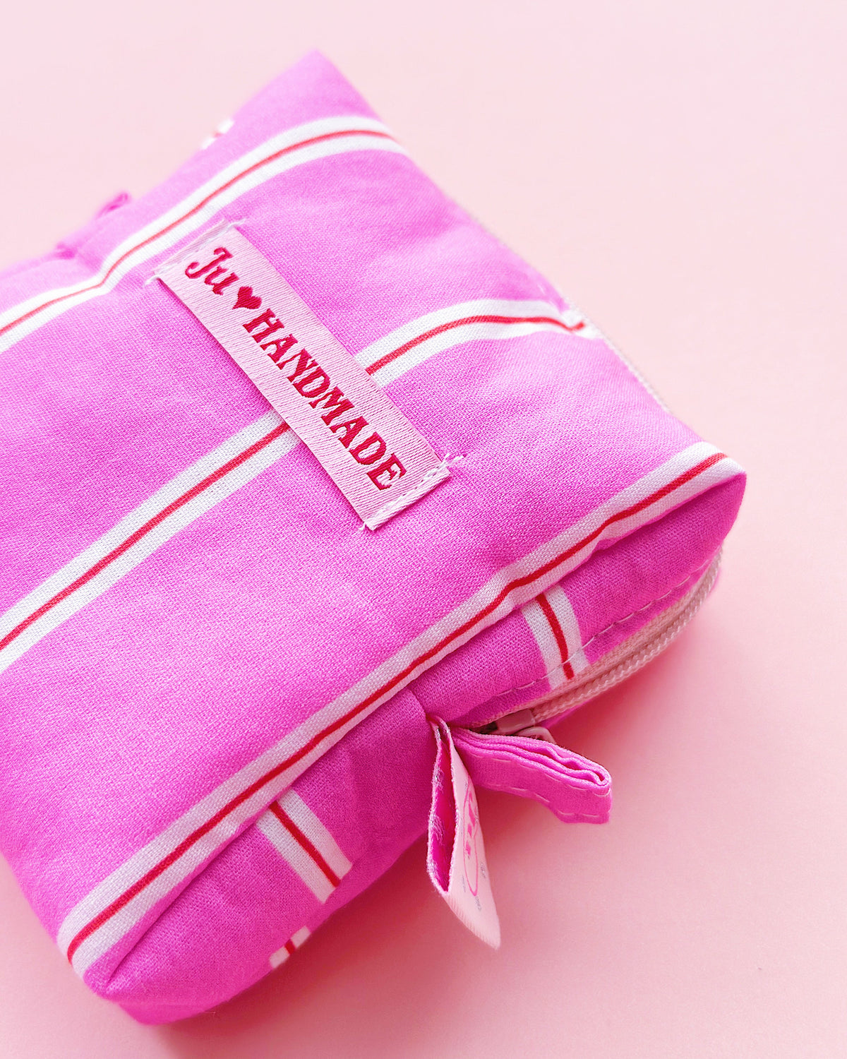 a boxy shape zipper pouch in pink striped fabric