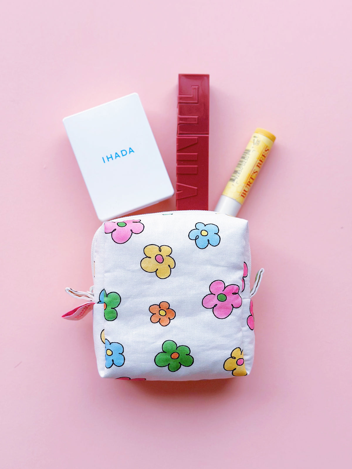 a cute colorful daisy zip up make up bag with small make up stuffs