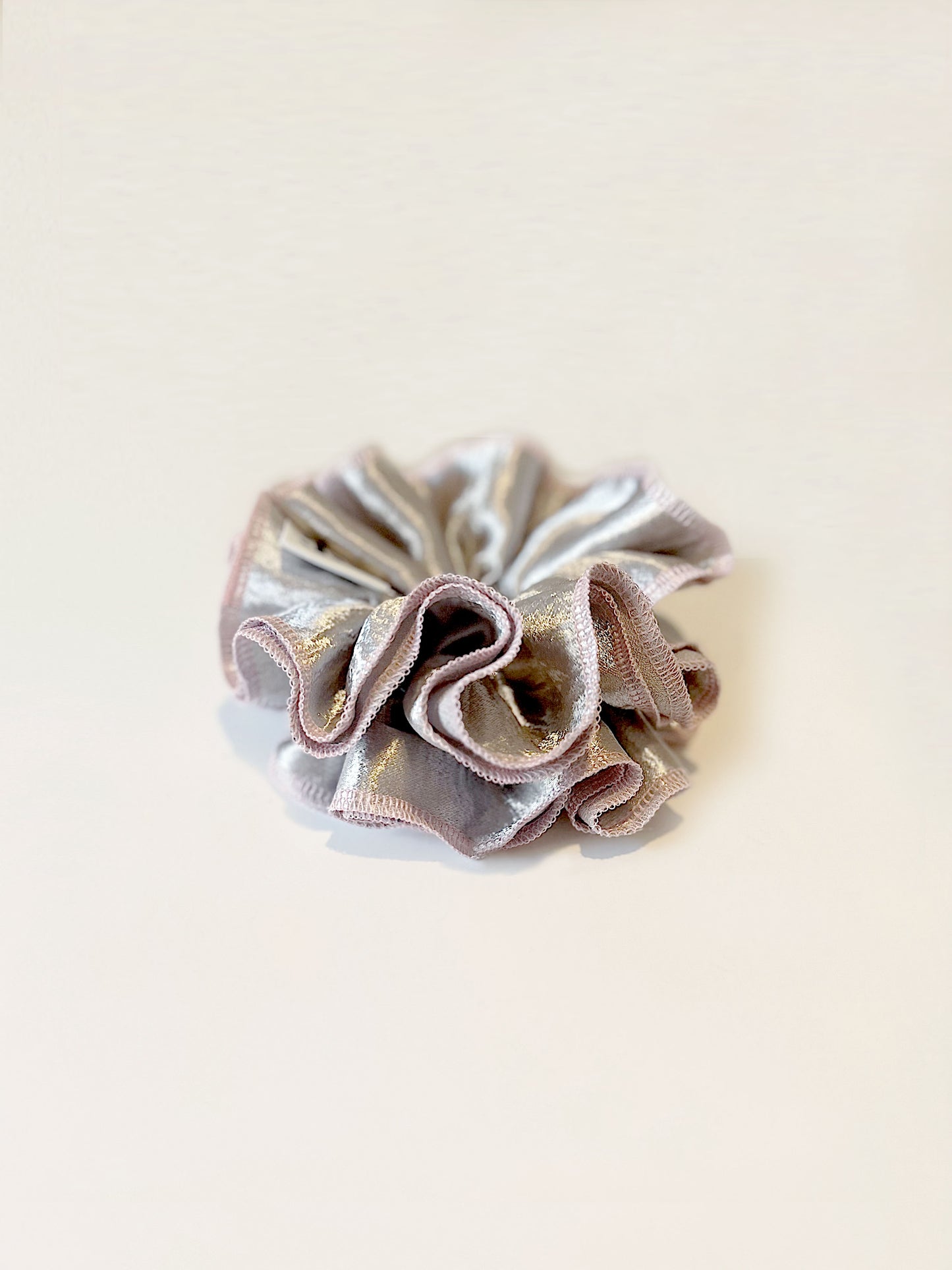 Oversized silver satin scrunchie with soft pink edges, shiny metallic hair accessory for Christmas party or festive hairstyles.