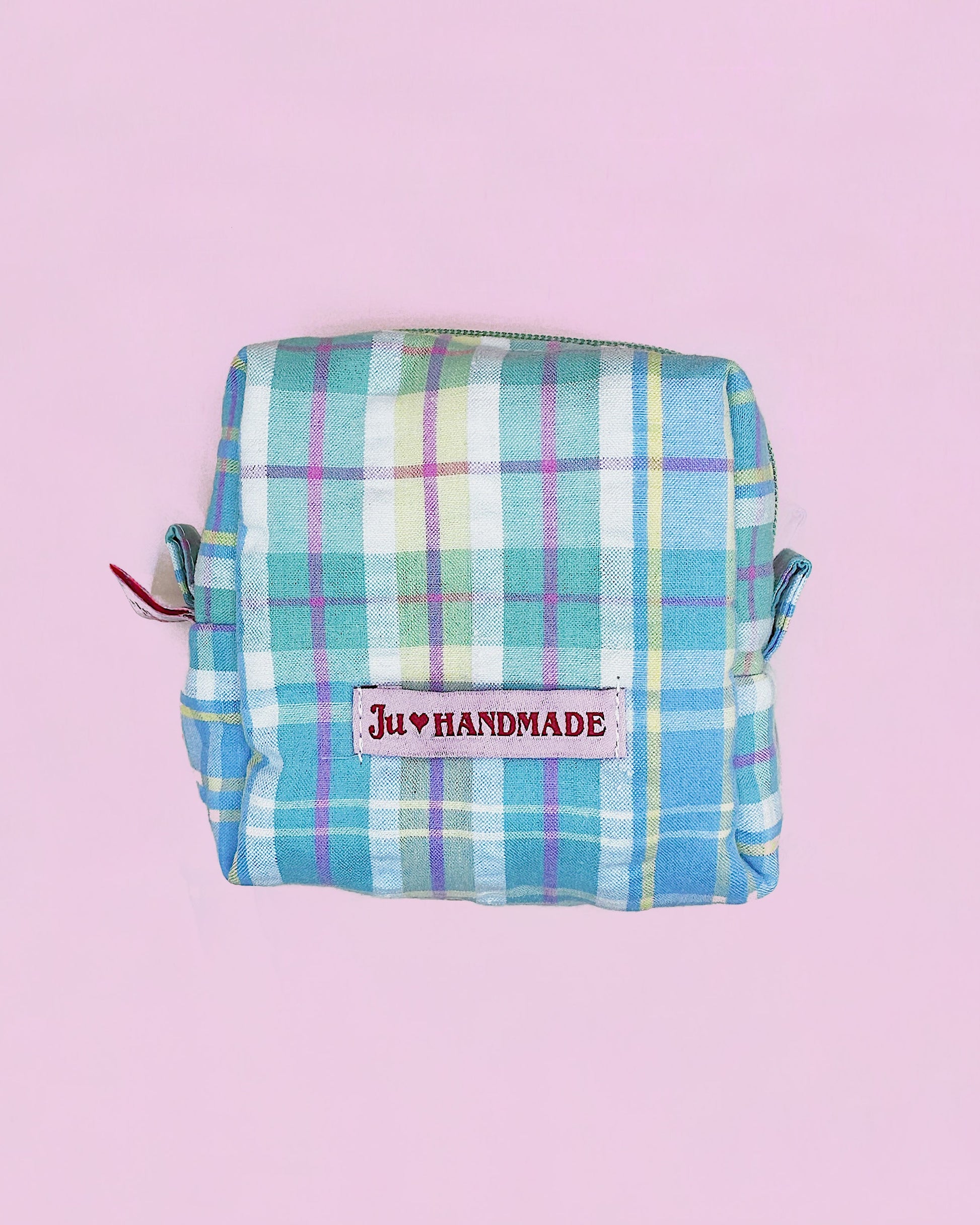 Handmade pink plaid quilted zipper pouch with cotton lining, boxy 10×10×5cm design, placed on a pastel pink background.